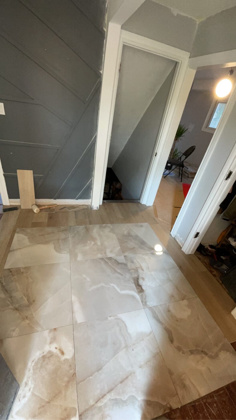 Large-format marble-look tile flooring installed through the main entry.