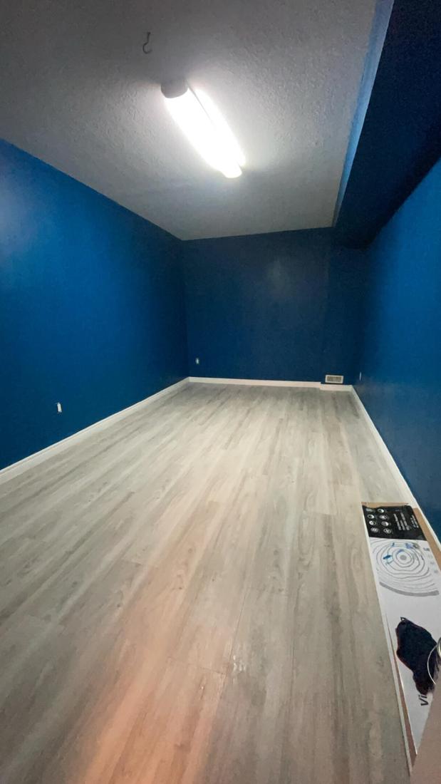 Basement flooring upgrade — new flooring, pot lights, and a smooth drywall finish.