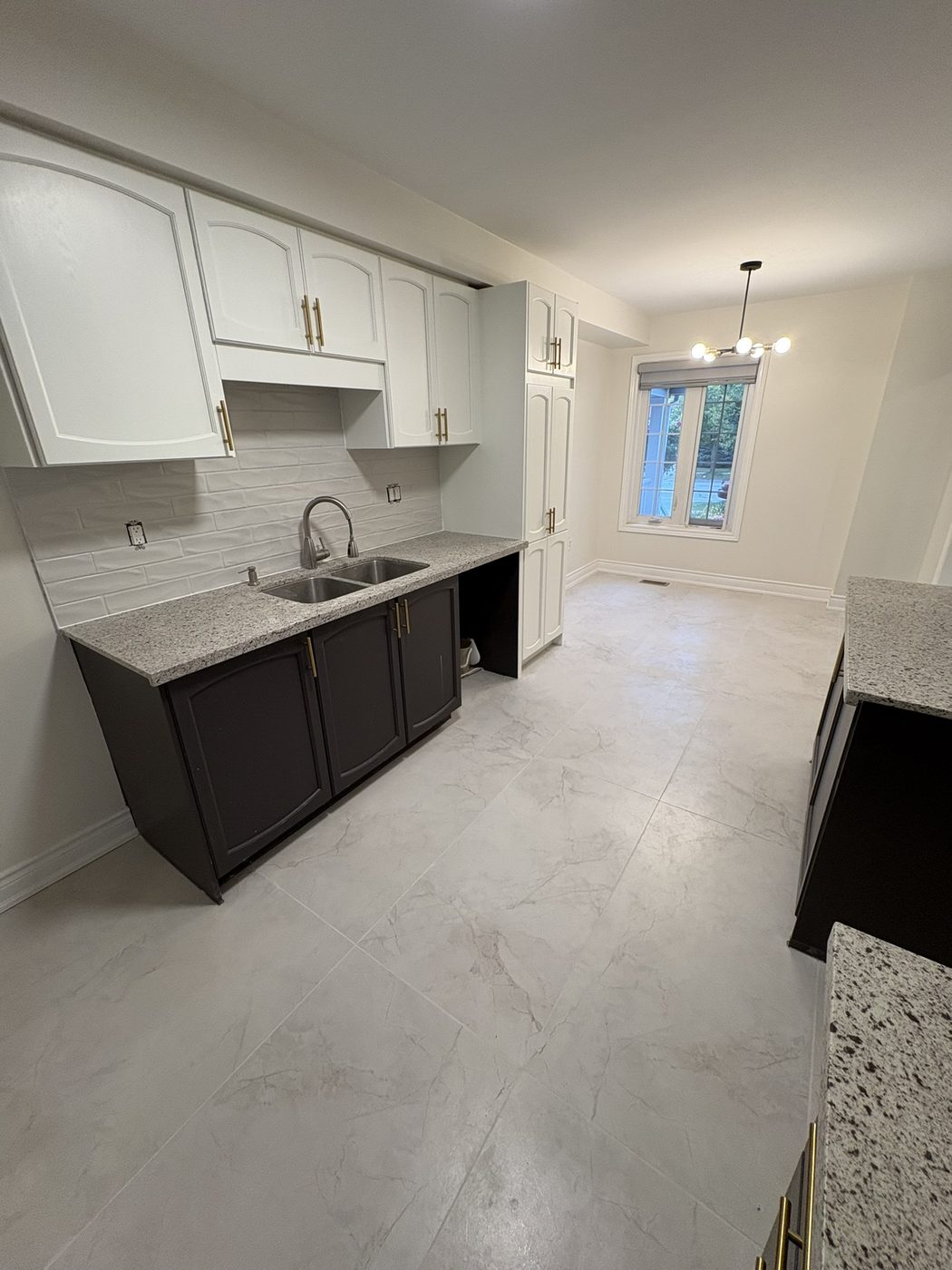 Bright white kitchen refresh with updated cabinetry, corner sink, and clean tile flooring.